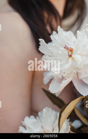 Großes Bouquet von Pfingstrosen in weiblichen Händen. Nicht erkennbare Frau mit einem Strauß rosa Pfingstrosen Stockfoto