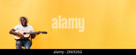 In voller Länge Foto von Angeregten künstlerische Mann, der seine Gitarre spielen. Auf gelben Hintergrund. Stockfoto