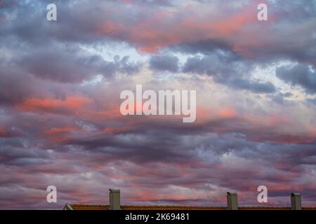 Feurig rot beleuchtete Unterseite der Wolken nach Sonnenuntergang Stockfoto