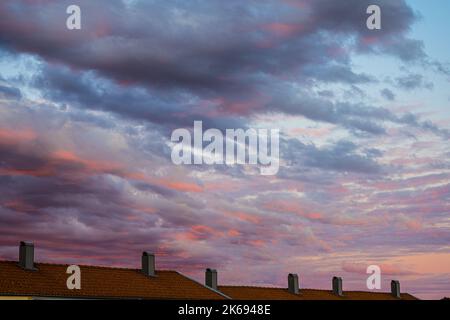 Feurig rot beleuchtete Unterseite der Wolken nach Sonnenuntergang Stockfoto