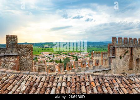 Stadt Soave und Weinberge von der Burgmauer der mittelalterlichen Burg Castello di Soave. Blick auf die Berge Lessini und die Po-Ebene an einem bewölkten Tag i Stockfoto