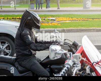 Moskau, Russland - 1. Mai 2019: Motorradfahrer mit Schutzausrüstung und Predator-Helm auf einem Motorrad auf einer Stadtstraße Stockfoto
