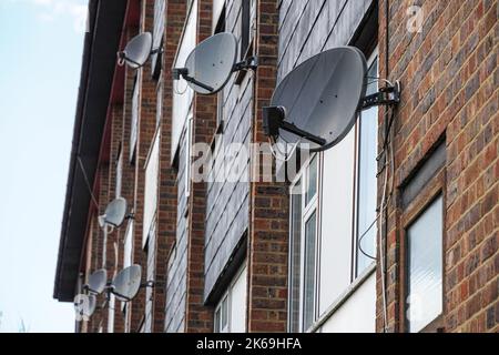 Satellitenschüsseln an einer Wand eines Wohnblocks, London, England, Großbritannien Stockfoto