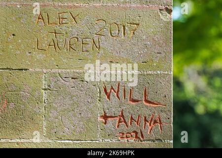 Tiefer geschnitzt mit Namen und Daten, die Paare an der Wand hinterlassen haben Stockfoto