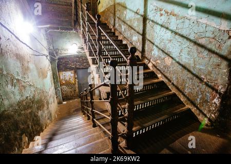 Alte, geschmiedete eiserne Treppe in einem schäbigen historischen Gebäude Stockfoto