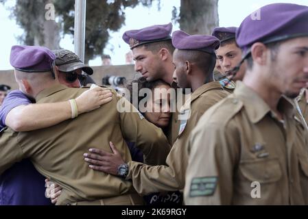 (221012) -- GEDERA (ISRAEL), 12. Oktober 2022 (Xinhua) -- Soldaten und Verwandte nehmen am 12. Oktober 2022 an der Beerdigung eines israelischen Soldaten auf dem Militärfriedhof in Gedera, Zentralisraelien, Teil. Der israelische Soldat wurde am Dienstag bei einem Drive-by-Schussangriff im besetzten Westjordanland getötet, inmitten der eskalierenden Gewalt zwischen Israel und den Palästinensern. (Ilan Assayag/JINI über Xinhua) Stockfoto