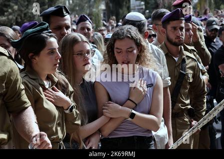 (221012) -- GEDERA (ISRAEL), 12. Oktober 2022 (Xinhua) -- Soldaten und Verwandte nehmen am 12. Oktober 2022 an der Beerdigung eines israelischen Soldaten auf dem Militärfriedhof in Gedera, Zentralisraelien, Teil. Der israelische Soldat wurde am Dienstag bei einem Drive-by-Schussangriff im besetzten Westjordanland getötet, inmitten der eskalierenden Gewalt zwischen Israel und den Palästinensern. (Ilan Assayag/JINI über Xinhua) Stockfoto