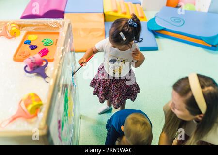 Kids Färbung das Zellophan im Kindergarten, kreative Aktivitäten für Vorschulkinder Spielzeug im Hintergrund. Hochwertige Fotos Stockfoto