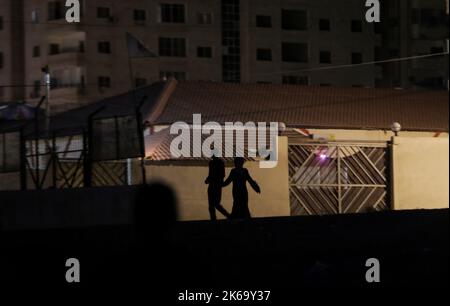 12. Oktober 2022, Gaza-Stadt, der Gazastreifen, Palästina: Palästinenser gehen auf einer dunklen Straße in Gaza-Stadt (Foto: © Mahmoud Issa/Quds Net News via ZUMA Press Wire) Stockfoto