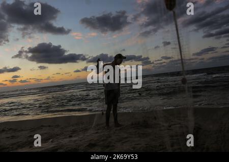 12. Oktober 2022, Gaza-Stadt, der Gazastreifen, Palästina: Palästinensische Flüchtlinge fischen am Strand im Westen von Gaza-Stadt. (Bild: © Mahmoud Issa/Quds Net News via ZUMA Press Wire) Stockfoto