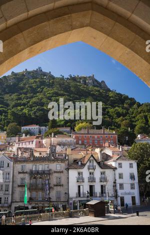 Sintra Dorf mit Blick auf das Schloss Dos Mouros auf einem Hügel vom Torbogen am Nationalpalast von Sintra, Sintra, Portugal. Stockfoto