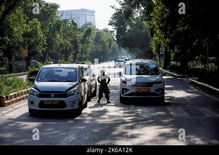 Neu-Delhi, Indien. 1. Oktober 2022. Ein armes Kind spielt Akrobatik vor Fahrzeugen an einer Ampel. Arme und unterprivilegierte Kinder führen oft Akrobatik oder Jonglierhandlungen durch, um Almosen an den Verkehrssignalen in Delhi zu suchen, wo Betteln kein Verbrechen gemäß dem Gesetz des Landes ist. Trotz der Bemühungen von Behörden und NGOs, die Kinder zu rehabilitieren, ist es ein üblicher Anblick an vielen Verkehrskresten in der Landeshauptstadt. (Bild: © Amarjeet Kumar Singh/SOPA-Bilder über ZUMA Press Wire) Stockfoto