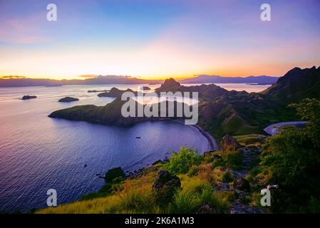 Panoramablick auf die majestätische Insel Padar bei herrlichem Sonnenuntergang. Aufgrund der hohen iso-empfindlichkeit treten leichte Scharfstellung und Rauschen auf Stockfoto
