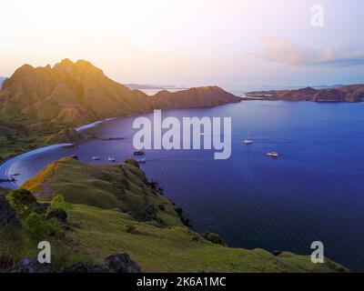 Panoramablick auf die majestätische Insel Padar bei herrlichem Sonnenuntergang. Aufgrund der hohen iso-empfindlichkeit treten leichte Scharfstellung und Rauschen auf Stockfoto