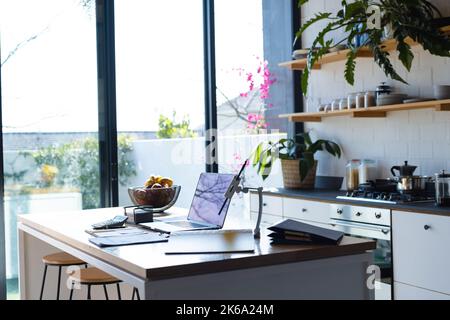 Allgemeiner Blick auf die moderne Küche mit Laptop und Tablet auf der Arbeitsfläche Stockfoto