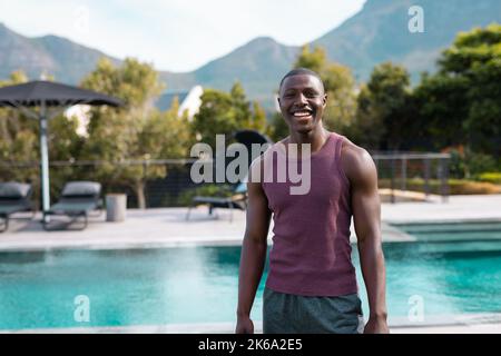 Porträt eines glücklichen afroamerikanischen Mannes, der im Garten lächelt Stockfoto