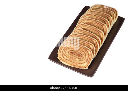 Geschnittenes Bolo de rolo auf einer braunen Platte (weißer Hintergrund). Stockfoto