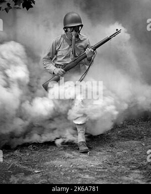 Soldat mit Gewehr während der Ausbildung der Gasmaske in Fort Belvoir, Virginia, während des Zweiten Weltkriegs, 1942. Stockfoto