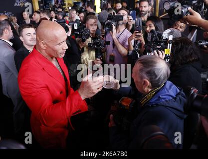 New York, Usa. 12. Oktober 2022. Dwayne 'The Rock' Johnson und das Mitglied der Wrestling Hall of Fame und Fotograf George Napolitano heben eine Brille, die mit Dwayne 'The Rock' Johnsons Marke Tequila gefüllt ist, als Johnson am 12. Oktober auf dem roten Teppich für die New Yorker Premiere von DC „Black Adam“ im AMC Empire 25 auf dem Times Square ankommt, 2022 in New York City. Foto von John Angelillo/UPI Credit: UPI/Alamy Live News Stockfoto