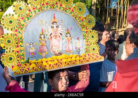 Anhänger tauchen Durga Idol auf dem Fluss Ganges während des letzten Tages des Durga Puja Festivals ein. Stockfoto