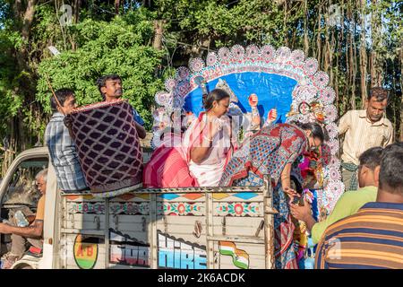 Anhänger tauchen Durga Idol auf dem Fluss Ganges während des letzten Tages des Durga Puja Festivals ein. Stockfoto
