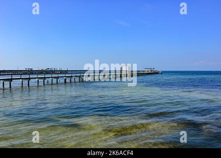 Brackwasser in Charlotte Harbor mit Fischerpiers und Docks, die sich in die minimalistische Wasserlandschaft mit blauem Himmel erstrecken, Bokeelia, Pine Island, FL Stockfoto