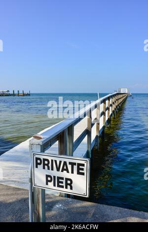 Unterschreiben Sie eine von vielen privaten Pfeilern, die in den Charlotte Harbour auf Pine Island in Lee County, Florida ragen, bevor der Windhauch Ian das Gebiet verwüstet hat Stockfoto