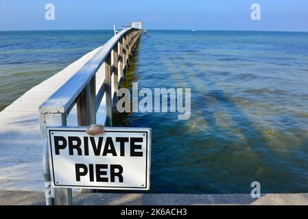 Unterschreiben Sie eine von vielen privaten Pfeilern, die in den Charlotte Harbour auf Pine Island in Lee County, Florida ragen, bevor der Windhauch Ian das Gebiet verwüstet hat Stockfoto