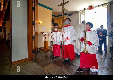 Übermüdet kommen multirassische Altarjungen, um an der Messe in einer katholischen Kirche in Tustin, CA, teilzunehmen. Stockfoto