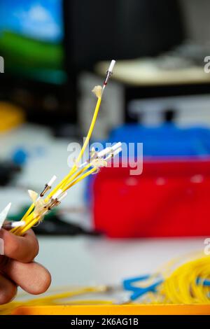 Techniker spaltet eine Lichtwellenleiter, ein entscheidender Prozess für eine gute Verschmelzung von Lichtwellenleitern. Stockfoto