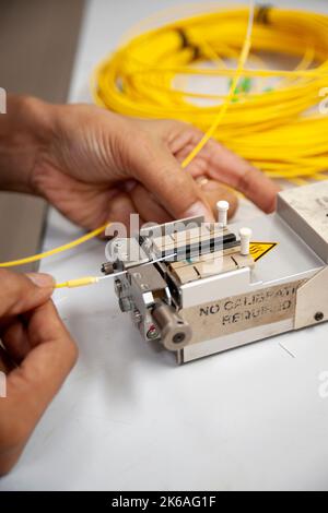 Techniker spaltet eine Lichtwellenleiter, ein entscheidender Prozess für eine gute Verschmelzung von Lichtwellenleitern. Stockfoto