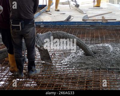 Bauarbeiter, der Beton für eine Gebäudebodenplatte gießt Stockfoto