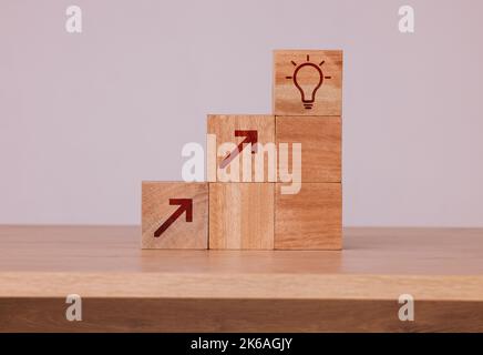 Holz, Blöcke und Idee mit Glühbirne Ikone für Kreativität, Innovation und Entwicklung mit Holzwürfeln vor Studiohintergrund. Brainstorming Stockfoto