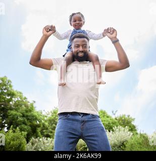 Spaß zu haben zählt als wertvolle Bindungszeit. Porträt eines Vaters, der seine Tochter auf den Schultern im Freien trägt. Stockfoto