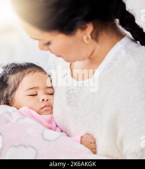 Liebenswert kleines Mädchen Gefühl warm und sicher, während friedlich schlafen in ihren liebevollen Armen Mutter zu Hause. Fürsorgliche Mutter hält und schaukelt sie niedlich Stockfoto