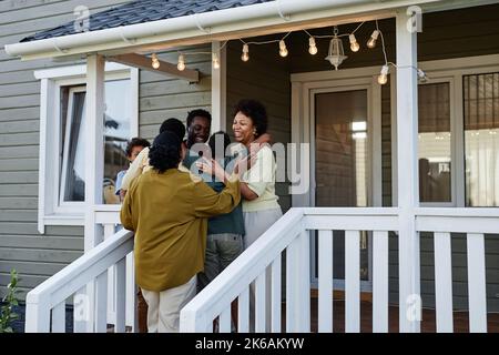 Porträt der glücklichen schwarzen Familie umarmt, während auf der Veranda des neuen Hauses, kopieren Raum stehen Stockfoto