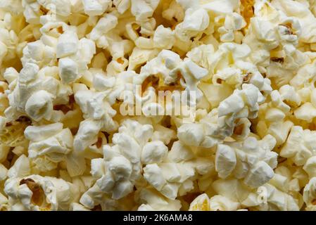 Schüssel mit frischem und schmackhaftem Popcorn Hintergrund. Nahaufnahme Stockfoto