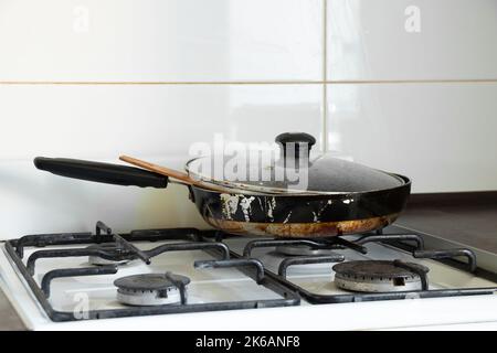 Gasherd und schmutzige Bratpfanne in der Küche in einer Wohnung in der Ukraine, Küchenmöbel und -Geräte, Kücheninnenraum Stockfoto