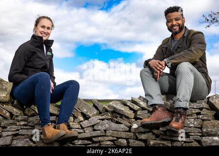 REDAKTIONELLE VERWENDUNG NUR JB Gill (rechts) mit Jo Lawrence, Senior Manager Arla Foods, als er sich mit Arla Cravendale auf einer Farm in den Yorkshire Dales zusammenschließt, um die Veröffentlichung von „Everybody's Free A-Cowppella Style“ anzukündigen, der die Marke Free to Graze Standard und ein breiteres PFLEGEPROGRAMM feiert. Ausgabedatum: Donnerstag, 13. Oktober 2022. Stockfoto