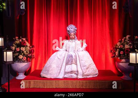 Toronto, Kanada. 12. Oktober 2022. Eine als Königin gekleidete Frau posiert auf einem Thron. Die „Queen's Ball“ Bridgerton Experience ist ein immersiver Ball aus der Regency-Ära mit Musik, die vom Bridgerton-Soundtrack inspiriert ist, einer der am meisten gesehenen Shows auf Netflix. (Foto von Katherine Cheng/SOPA Images/Sipa USA) Quelle: SIPA USA/Alamy Live News Stockfoto