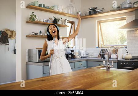 Reinigung, Kopfhörer und schwarze Frau, tanzen, singen mit Musik im Haus. Mädchen, singen und tanzen in der Wohnung, sauber zu Hause, Küche oder Zimmer, während Stockfoto