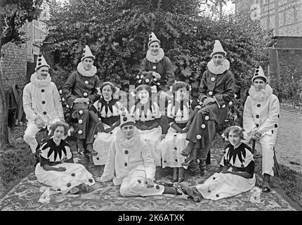 Eine Gruppe von Männern und Frauen in Pierrot (Clown) Kostümen, Norfolk, England, Großbritannien c. 1930. Ein Pierrot ist eine Figur der Pantomime und der Commedia dell’arte, deren Ursprünge in der italienischen Truppe des späten 17. Jahrhunderts liegen, die in Paris auftrat und als Comédie-Italienne bekannt ist. Dies ist einem alten Schwarz-Weiß-Negativ entnommen – einem Vintage 1920s/30s-Foto. Stockfoto