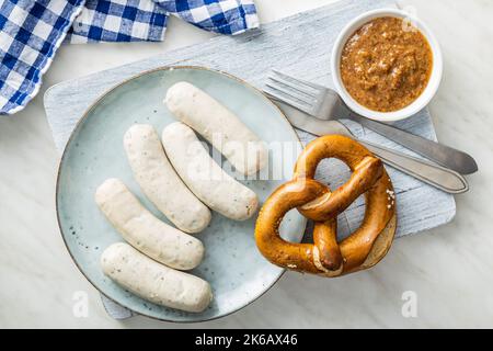 Traditionelle bayerische Weißwürste auf dem Teller und Brezen. Draufsicht. Stockfoto