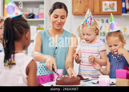 Ein Schüler Geburtstag zu feiern macht immer Spaß. Ein Vorschulkind feiert einen Geburtstag in der Klasse. Stockfoto