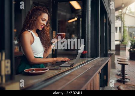 Remote-Arbeit im Café, Laptop und Blogger, Frau mit einem Kaffee, arbeiten an Content-Forschung für Blog. Junge, kreative Schriftsteller und freiberufliche Arbeit, soziale Stockfoto