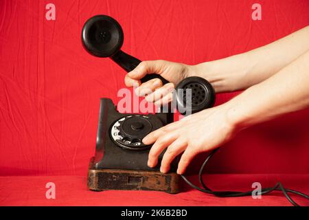 Altes Retro-Telefon schwarz und die Hand der Frau Nahaufnahme, Anruf am Telefon, Technologie Stockfoto