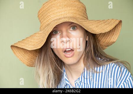 Das Mädchen im Hut macht ein überraschendes Gesicht, die Emotion der Überraschung und Freude, Freude Stockfoto