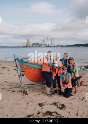 Teamfoto der weiblichen Juniper St Ayles-Skiff-Crew mit Sitz in Cromarty, Ross & Cromarty, Schottland, Großbritannien - schottischer Frauen-Küstenruderclub Stockfoto