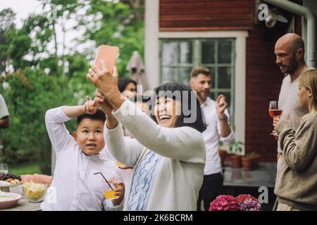 Glückliche Großmutter nimmt Selfie über Smartphone mit Enkeln auf der Party Stockfoto