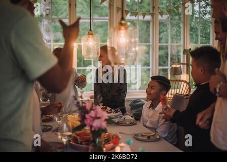 Freunde feiern Geburtstagsfeier mit Familie am Esstisch Stockfoto
